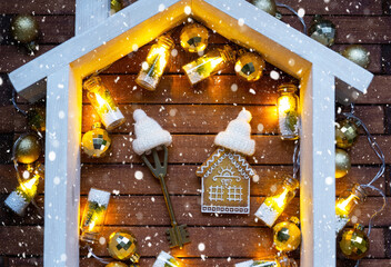Key to house with a keychain tiny home on wooden background with Christmas decor layout. Gift for New Year, Christmas. Building, project, moving to new house, mortgage, rent and purchase real estate