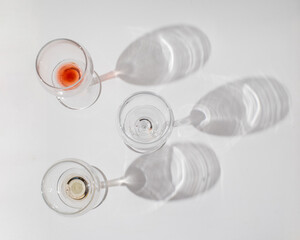 Wine of different varieties in glasses on a white background. Fashionable hard shadows from glasses.