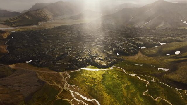 Sun rays shining down in aerial view of  Landmannalaugar Iceland  viewing the landscape terrain.