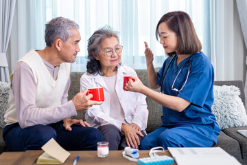 Senior couple get medical advice visit from caregiver nutritionist at home while having suggestion on herbal hot chamomile tea drink for longevity, healthy sleep and cure to insomnia