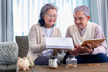 Senior Asian couple is planning on retirement saving fund looking at their income and expense and annual pension after taxes for elder long term financial investment and budget concept - obrazy, fototapety, plakaty