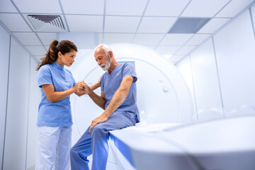 Doctor preparing and encouraging senior man before MRI scan or CT procedure in hospital.