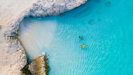 Tres Trapi Steps Triple Steps Beach, Aruba a popular beach among locals and tourists for diving and snorkeling, A couple of men and woman in a crystal clear ocean in the Caribbean