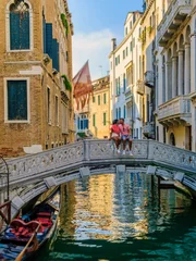Cercles muraux Pont du Rialto a couple of men and women on a city trip in Venice Italy sitting at a bridge in Venice, Italy. cityscape citytrip Venice Italy during summer