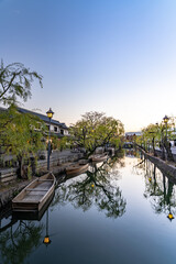Naklejka premium Kurashiki Bikan Historical Quarter in dusk. Townscape known for characteristically Japanese white walls of residences and willow trees lining banks of Kurashiki River. Okayama Prefecture, Japan