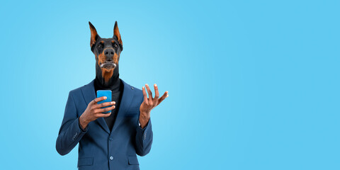 Businessman with dog head using smartphone on empty blue background