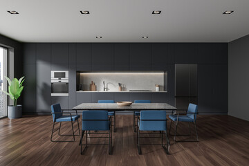 Modern home kitchen interior with dining table and cooking space, window