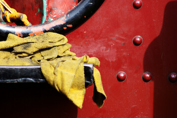 cleaning rag and close up detail of a red and black traction engine or steam-powered tractor