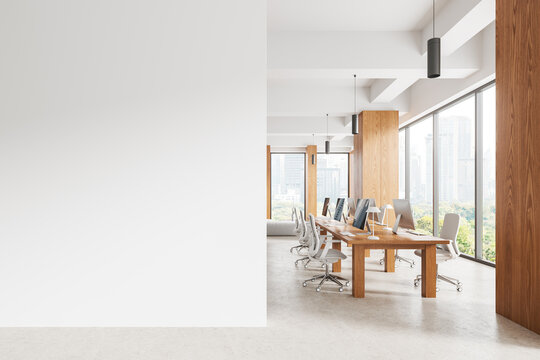 Light coworking interior with pc desktop and table near window. Mock up wall