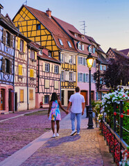 Couple on vacation in Colmar France colorful romantic city of Colmar in the evening, the Historic town of Colmar, Alsace region, France with beautiful canals called Le Petit Venice in summer - obrazy, fototapety, plakaty