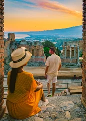 Foto op Canvas Taormina Sicily, couple watching the sunset at the Ruins of the Ancient Greek Theater in Taormina, Sicily. couple mid age on vacation in Sicilia during the summer holidays © Fokke Baarssen