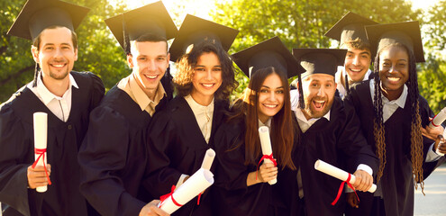 Group of happy cheerful positive diverse multiethnic college or university students in black caps...