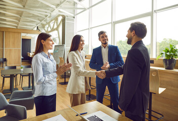 Business people meet in office, negotiate deals, make agreements and exchange handshakes. Happy,...