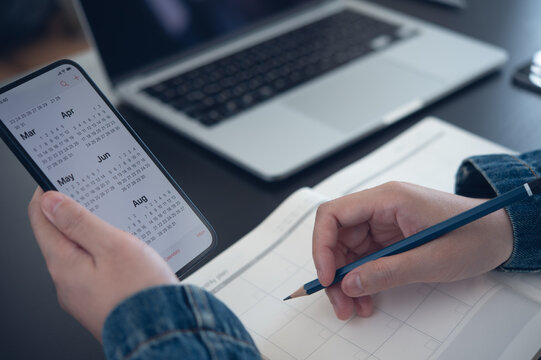 2024 Calendar event planner timetable agenda plan on organize schedule. Business woman using mobile phone with monthly calendar for event planning, Plan scheduling on notebook