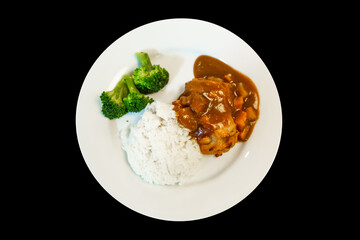Top view of chicken steak and rice on black background.