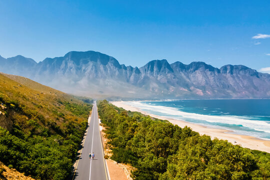 Kogelbay Beach Western Cape South Africa, Kogelbay Rugged Coast Line with spectacular mountain road. Garden Route. couple of men and women walking on the road, drone aerial view