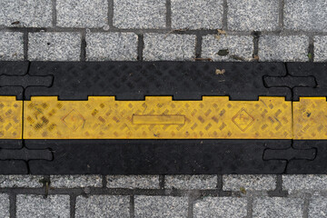 Cable protector cover. Yellow and black protective cable ramp for outdoor events.