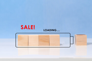Wooden cubes in the form of a loading battery and the inscription sale, loading. The beginning of the sale