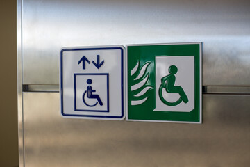 Green wheelchair sign with a person driving away from a fire. Symbol of a fireproof elevator in a...