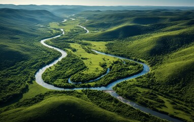 Aerial view of a winding river through vibrant green hills