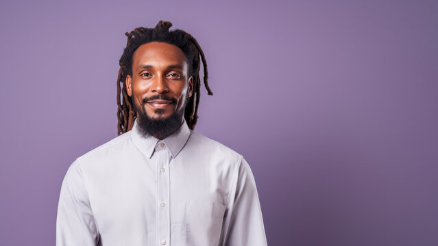 Insightful man in his 40s with ebony dreadlocks near purple wall
