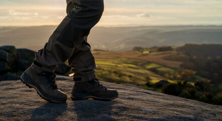 man in special boots walking in the mountains reaching the destination and on the top of mountain...
