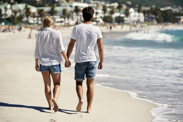 Couple, walk and back on beach, holding hands or outdoor in summer sunshine for vacation, thinking or travel. Man, woman and care with love, bonding or holiday by ocean for adventure in Naples, Italy