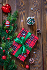 Christmas composition. Christmas tree branches and red gift box on the old wooden table