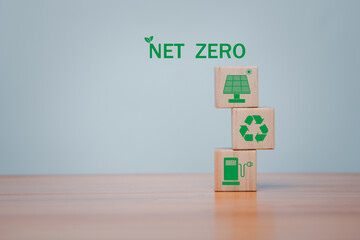 Wooden cubes with green net zero icon and green icon on grey background. Net zero and carbon neutral concept, plastic free, earth day, world environment day.