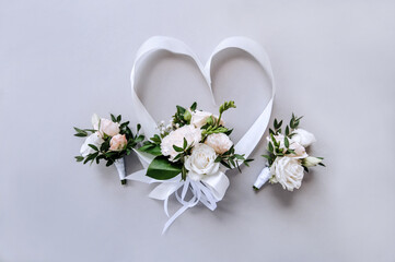 Beautiful bouquet of flowers with a heart-shaped ribbon on a white background. Wedding photography,...