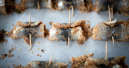 Baked rolled sardines with pine nut dressing, breadcrumbs, raisins, salt and pepper. Typical...
