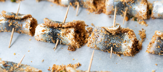 Baked rolled sardines with pine nut dressing, breadcrumbs, raisins, salt and pepper. Typical...