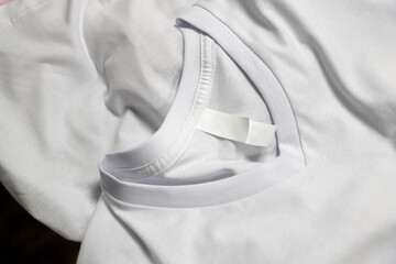 Basic folded white t-shirt on the table.  Mock up for branding t-shirt. Copy space
