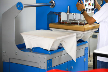 Press printing on colored t-shirts, press for printing images on fabric. Large industrial textile...