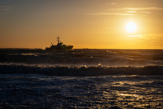 Schiff im Sonnenuntergang, wilde See






