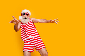 Photo of good mood carefree elderly guy wear new year swimsuit hat sunglass having disco fun empty space isolated yellow color background - obrazy, fototapety, plakaty