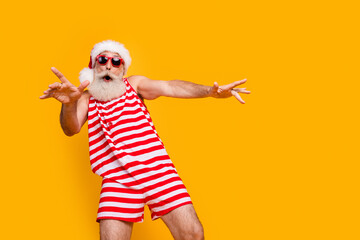 Photo of good mood carefree elderly guy wear new year swimsuit hat sunglass having disco fun empty space isolated yellow color background