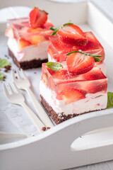 Delicious jelly cake with strawberries with fluffy cream layer.