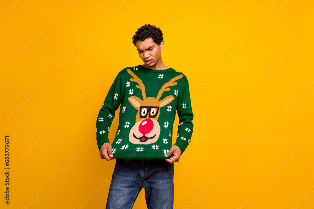 Wall mural Photo of unsatisfied young person look christmas deer print sweater empty space isolated on yellow color background