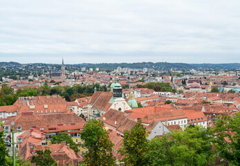 Fototapeta na wymiar Graz, Austria: Panoramic view of the city. Buildings, houses, streets and red roofs of Graz. Old town, view from the castle. 