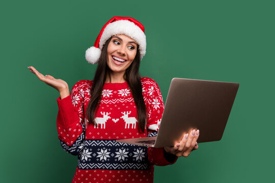 Photo of positive excited lady santa helper dressed print xmas sweater talking modern gadget isolated green color background