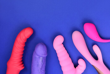Vibrator sex toys for women on a blue background top view stock photo images. Set of erotic vaginal toys images. Dildo and vibrators on a blue background with copy space - obrazy, fototapety, plakaty