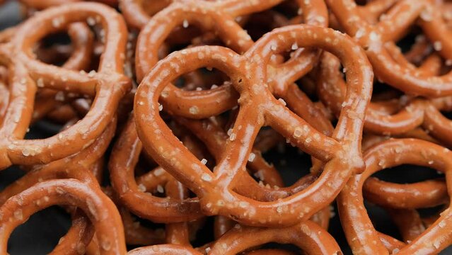 Large pretzels salted snack party food, background. Rotating video
