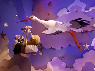 A store window  decorated for the end of year holidays, Christmas and New Year's Day. A stork flies and carries gifts