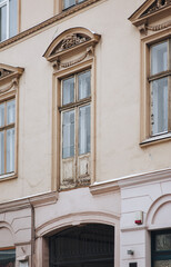 Obraz premium Windows with maskaron on the facade of an old house. Beautiful decorative architecture with relief and patterns. Lviv, Ukraine.