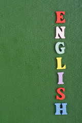 English word on green background composed from colorful abc alphabet block wooden letters, copy...
