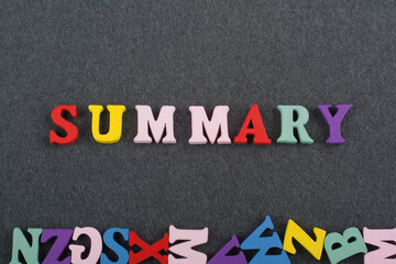 SUMMARY word on black board background composed from colorful abc alphabet block wooden letters,...