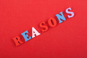 REASONS word on red background composed from colorful abc alphabet block wooden letters, copy space...