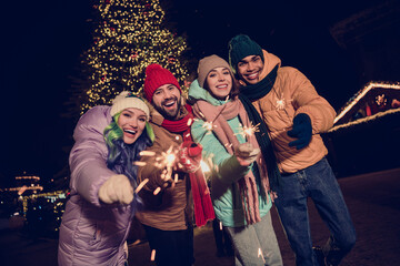 Photo of excited funky four buddies wear windbreakers firing bengal sticks together outside urban market park © deagreez