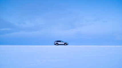 In the middle of nowhere. A car against the sky. A car journey through winter in Scandinavian...